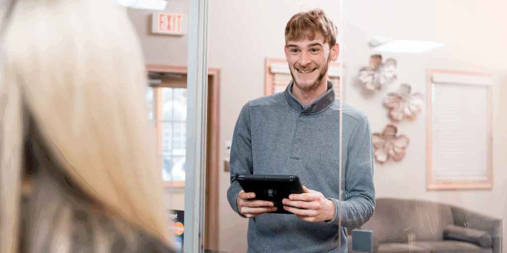 A patient checking in at the modern and welcoming front desk of Ohio Dental Implants & Oral Surgery