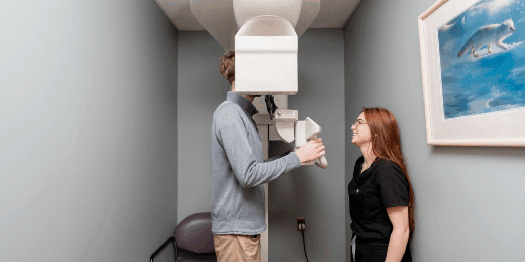 A clinical assistant positioning a patient for a high-resolution dental X-ray at the Ohio Dental Implants & Oral Surgery facility.
